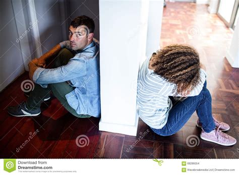 Couple Sitting On Opposite Sides Of The Wall Stock Photo Image Of