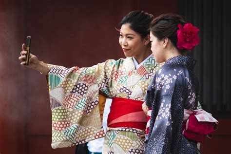 Two Japanese Girls Taking A Selfie With Smartphone Tourists Dressed In Traditional Colorful