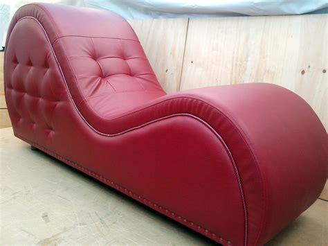 A Red Leather Chaise Lounge Chair Sitting On Top Of A Wooden Floor Next