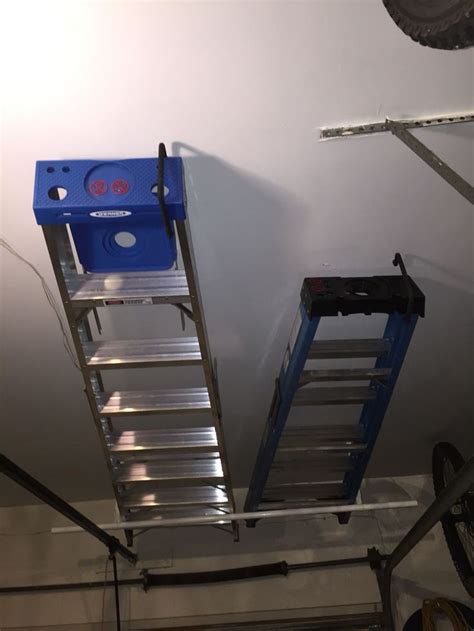 There Are Two Ladders Attached To The Ceiling And One Has A Blue Box On It