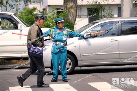 typical police officer directing traffic in a parking lot kyoto japan east asia asia stock