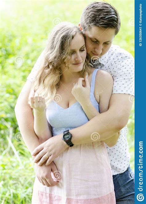 Natural Smiling Young Couple Hugging Outdoors Stock Image - Image of 