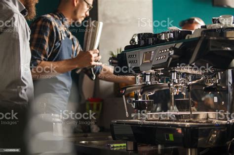 Two Male Baristas Standing Behind Bar Counter Preparing Drinks Stock