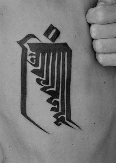 A Mans Chest With An Arabic Calligraphy Tattoo Design On His Left Side