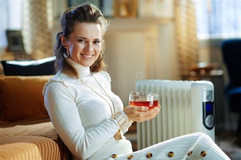 Smiling Elegant Woman Near Radiator And Warming With Tea Cup Stock