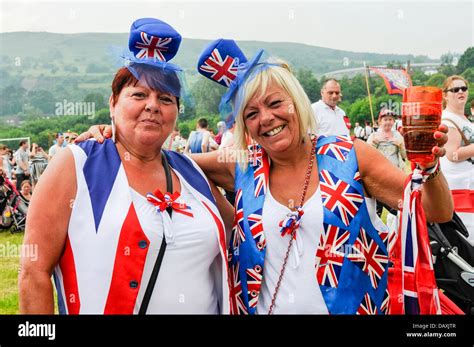 Two Women Watch The 12th July Orange Order Parade Wearing Union Flag