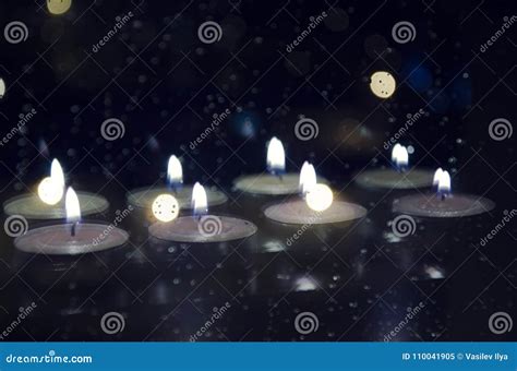 Reflection Of Many Candles In The Window Glass Behind Which The Dark