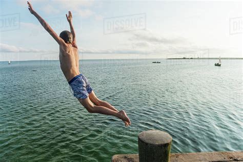 Boy Jumping Into Water Stock Photo Dissolve