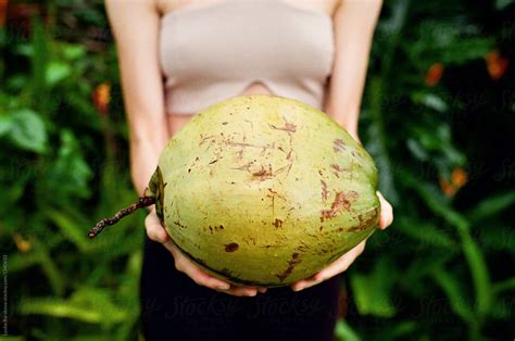 woman holding big coconut by stocksy contributor amor burakova stocksy