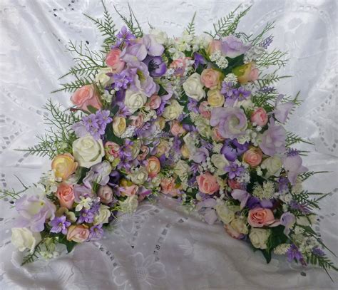 We exclusively use buttercream icing to frost our wedding cakes. Wedding cake filled with artificial flowers in ivory ...