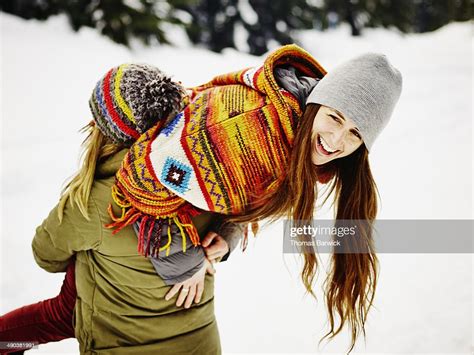 Woman Carrying Female Friend Over Shoulder Stock Photo - Getty Images