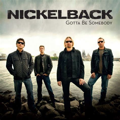 the band nickelback is standing on some rocks by the water with their arms around each other