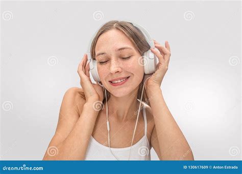 Portrait Of Young Woman Listening To Music She Uses White Headphones