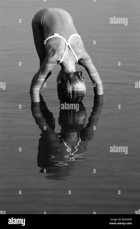 Girl Bending Over Into Still Water Bandw Stock Photo Alamy