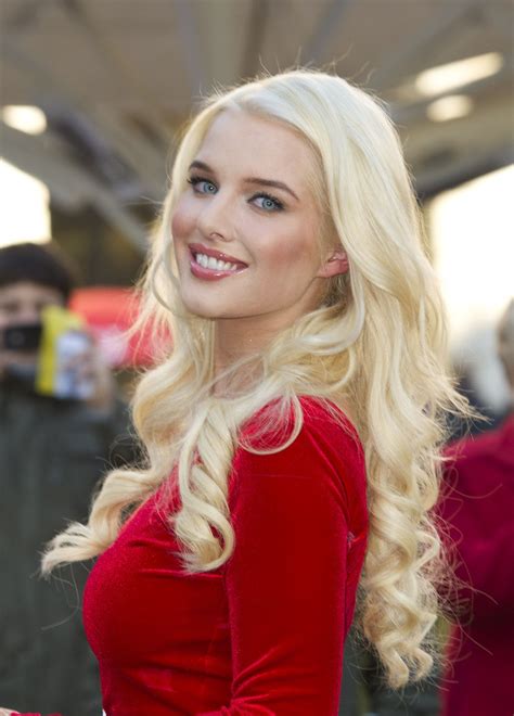 A Woman With Long Blonde Hair Wearing A Red Dress And Smiling At The