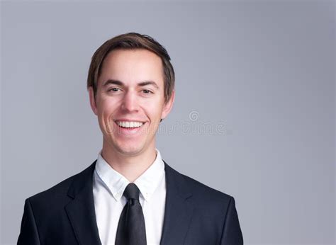 Portrait Of A Smiling Business Man In Suit Isolated On Gray Background