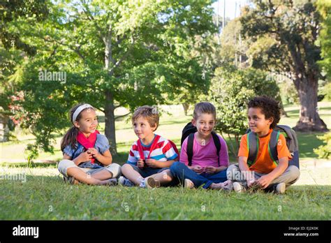 School Children Sitting On Grass Stock Photo Alamy