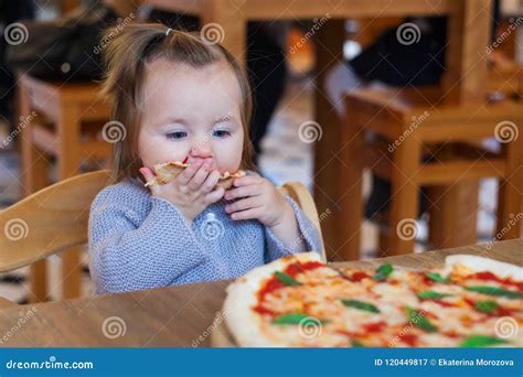 Sweet Adorable Child Baby Girl Eating Pizza At A Restaurant Stock