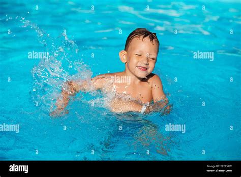 Happy Kid Playing In Blue Water Of Swimming Pool Little Boy Learning
