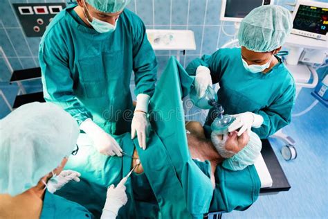 Group Of Surgeon At Work In Operating Room In Hospital Stock Photo