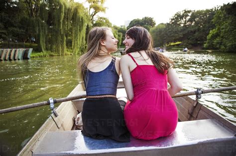 Rear View Of Lesbian Couple In Boat On Lake Stock Photo