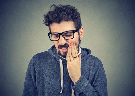 Man With Tooth Ache Suffering From Pain Touching Outside Mouth With