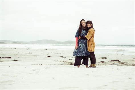 same sex lesbian couple hug on wild remote beach adventure in the wind photograph by cavan