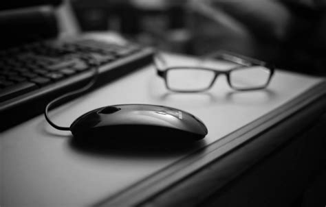 Old computers and keyboard covered by a lot of chips. Wallpaper table, mouse, glasses, black, black and white ...