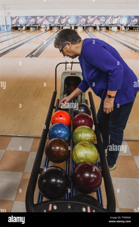 Older Woman Choosing A Bowling Ball At A Bowling Alley Stock Photo Alamy