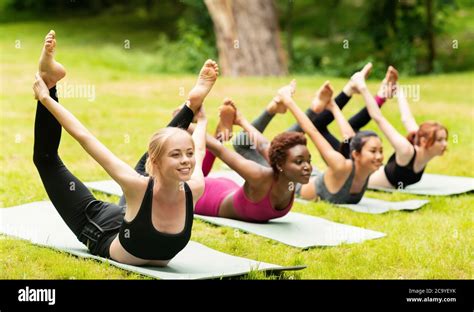 Happy Diverse Girls Doing Bow Yoga Pose On Outdoor Yoga Practice In