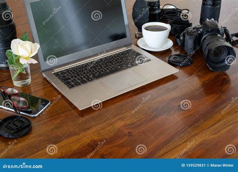 Photographer Workplace With Laptop Camera Lenses Coffee Cup And