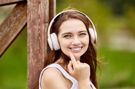 Lovely Caucasian Woman Is Listening To Music Outdoors Using Wireless