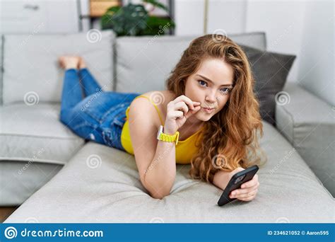 Young Caucasian Woman Lying On The Sofa Using Smartphone Mouth And Lips