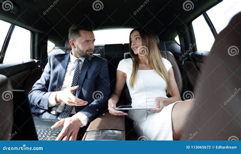 Successful People Working Together In Back Seat Of Car Stock Photo