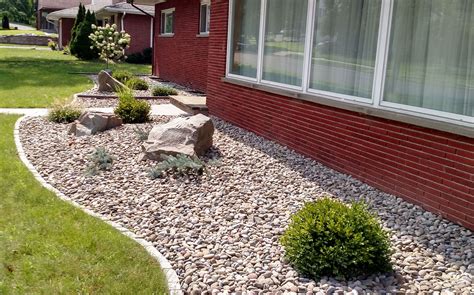 There's something special about rock painting. low maintenance foundation planting with stone mulch and ...