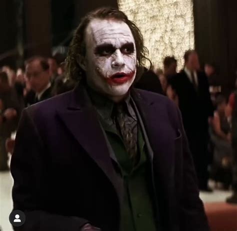 A Man Dressed As The Joker Is Standing In Front Of A Group Of Other People