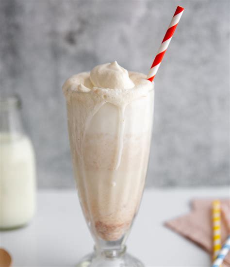 An Ice Cream Milkshake In A Glass With A Red And White Striped Straw