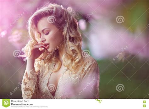 Beautiful Adult Girl Standing At Blossoming Tree In The Garden Stock