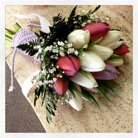 Bouquet colorato con rose arancio e salmone, gerbere fuxia, rosse e arancio, bacche rosse e altri fiori colori caldi con verde decorativo. Matrimonio colorato