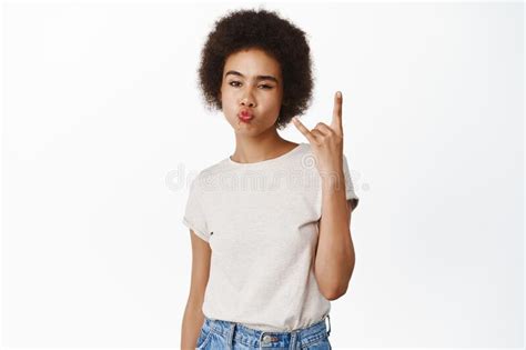 rock on smiling african girl with afro hair showing sassy heavy metal sign rock on gesture