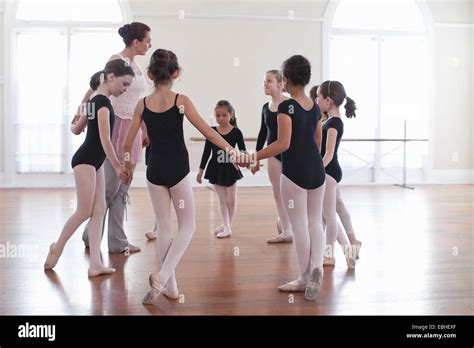 Ballet Teacher Holding Hands With Group Of Ballet School Girls Stock