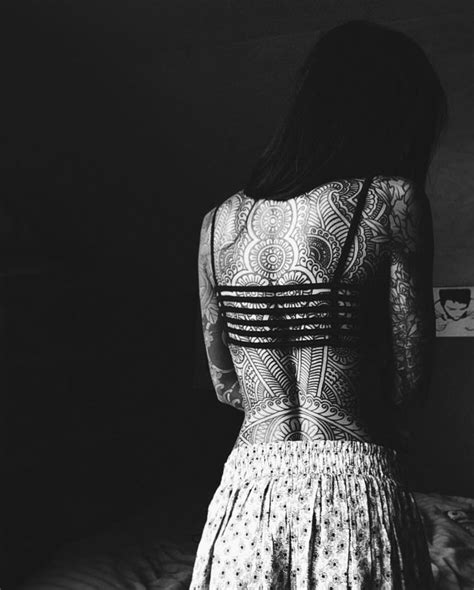 the back of a woman s dress standing on a bed in a dark room