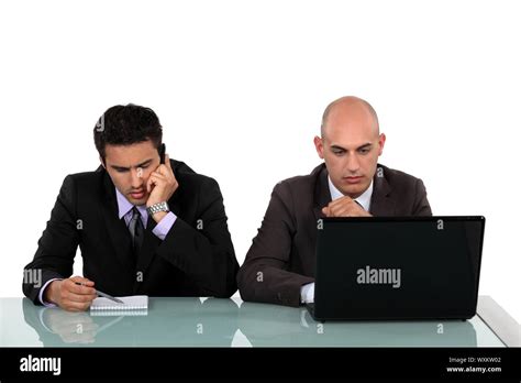 Serious Businessmen Working At A Desk Stock Photo Alamy