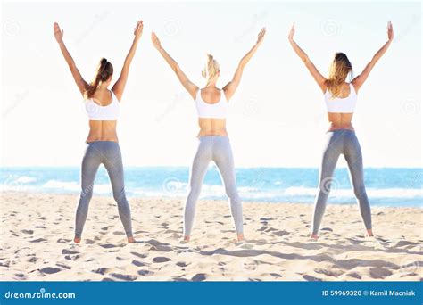 Grupo De Mujeres Que Practican Yoga En La Playa Foto De Archivo