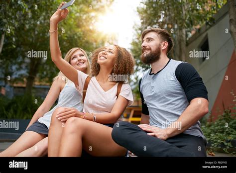 Three Young Friends Taking A Selfie With Cellphone Multiracial Group Of Young People Having Fun