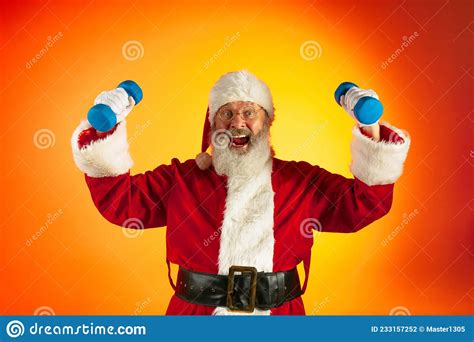 Portrait Of Happy Smiling Santa Claus Doing Exercises With Hand Weights Isolated On Red Yellow
