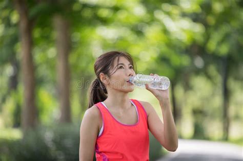 Attractive Young Runner Woman Drinking Water On Road When She Finished