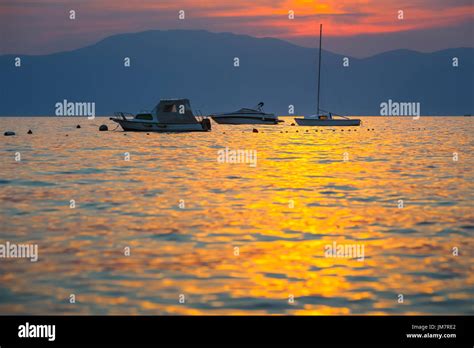 Sunset At Adriatic Sea With Boats Anchored And Island Cres In The