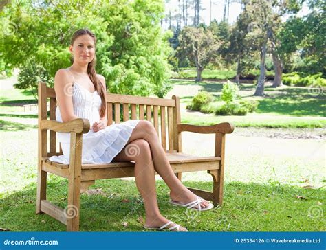 Frau Mit Ihren Beinen Kreuzte Das Sitzen Auf Einer Parkbank Stockfoto