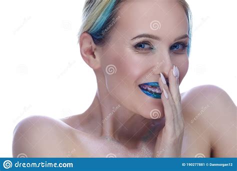 beauty portrait of shy laughing caucasian female with smooth skin wearing teeth brackets posing